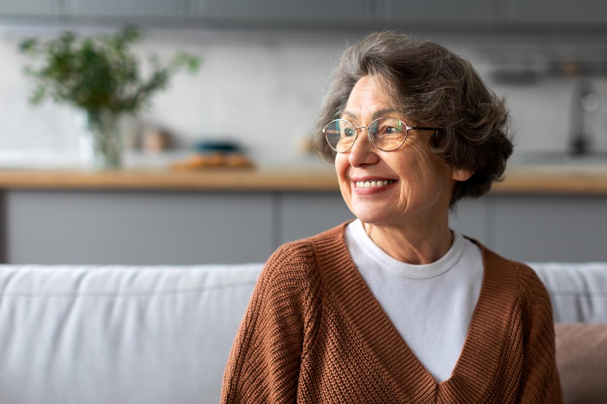 Portrait of happy senior woman relaxing on comfortable couch